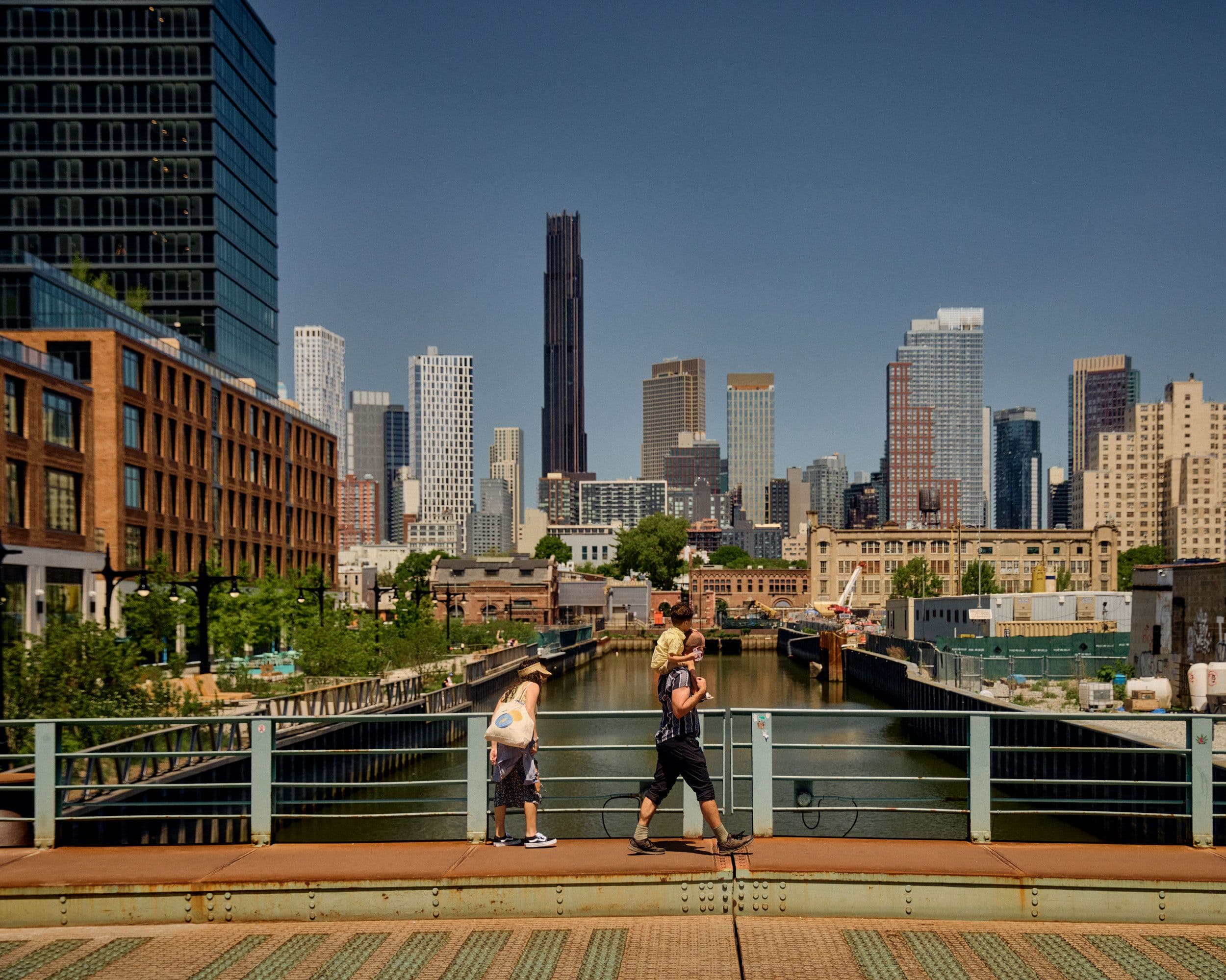 two adults and child walking across union street bridge over the gowanus canal
